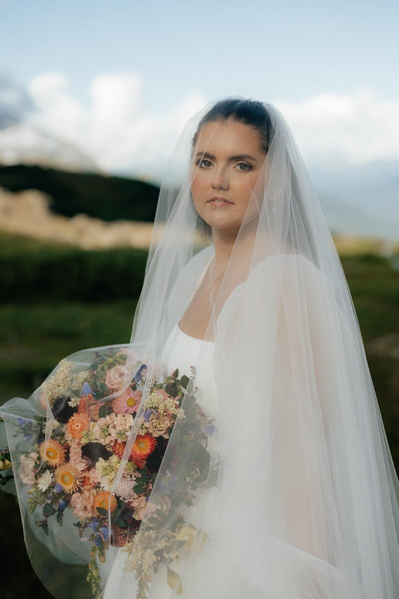 Bride holding bouquet during Seward Alaska elopement, photographed outdoors with natural florals.