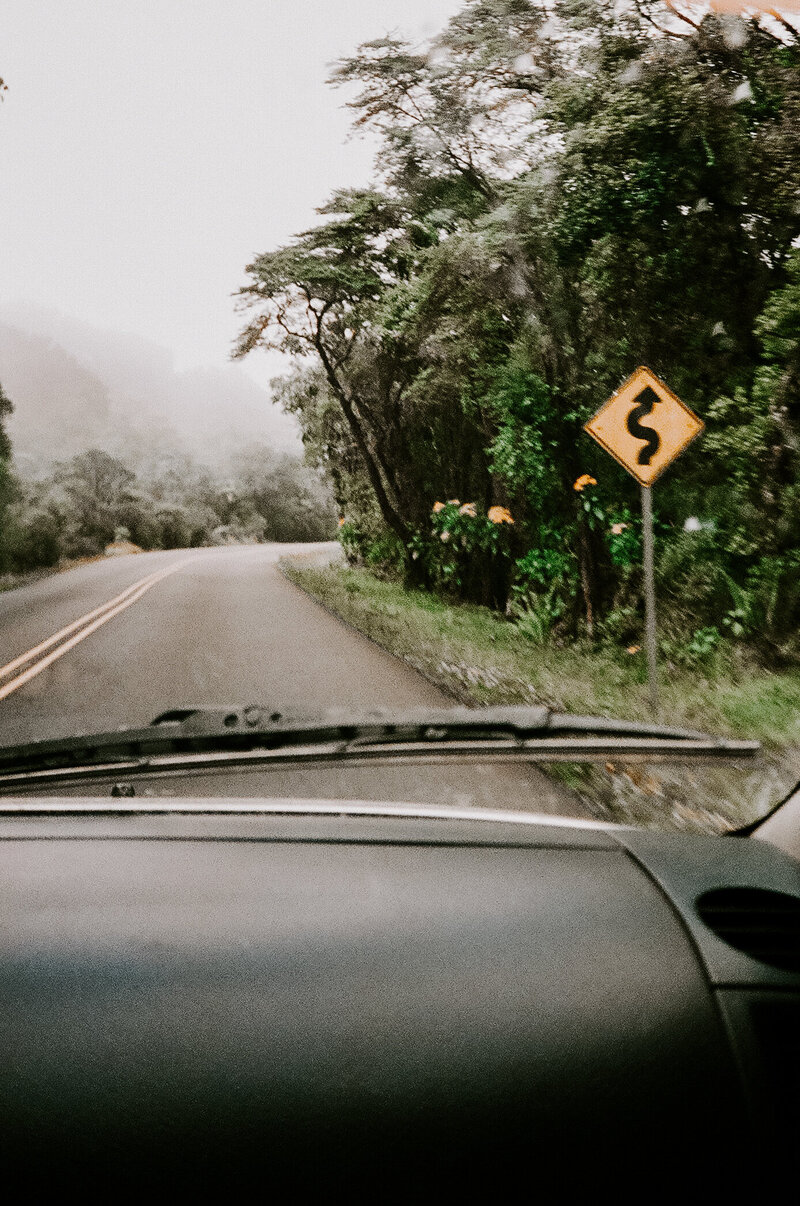 A road with a traffic sign that reminds drivers to stay alert for road conditions.