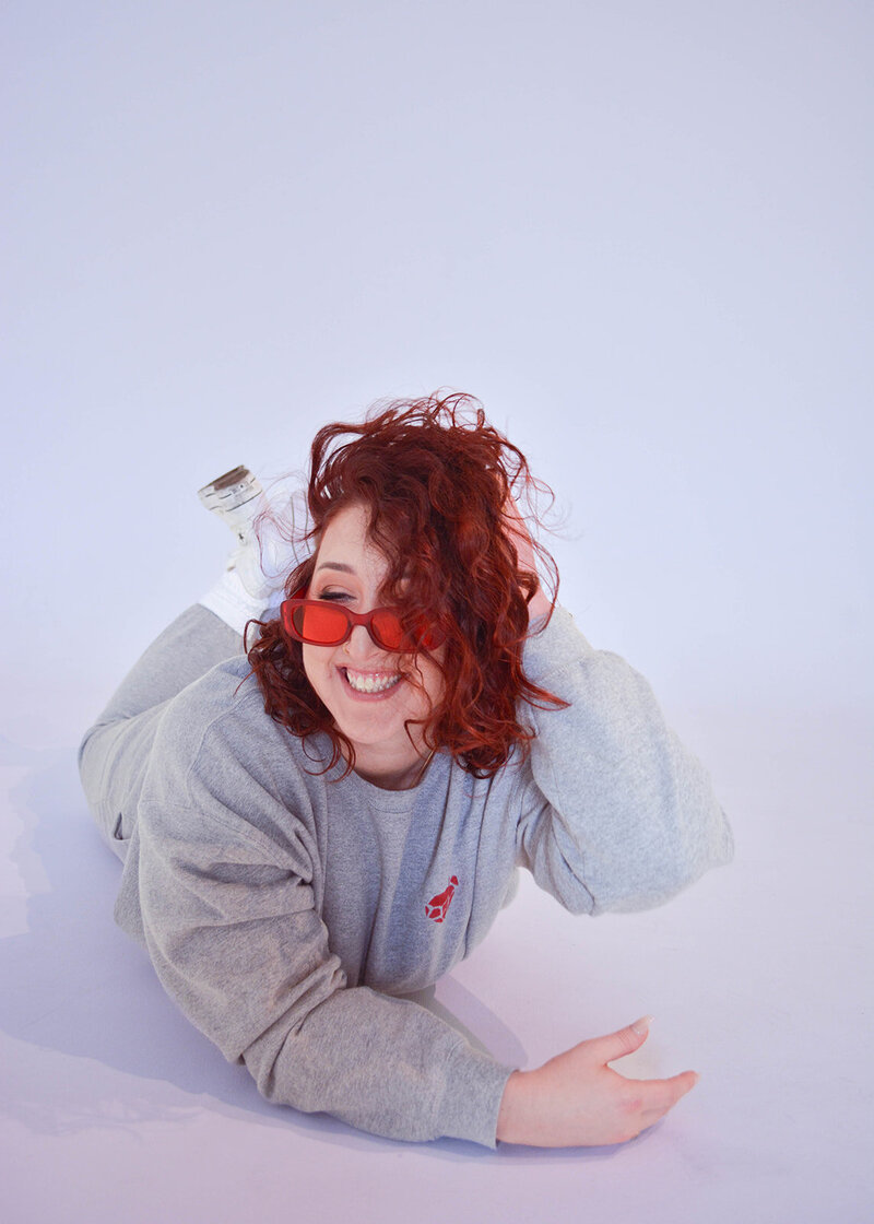 Erin Norris of Ruby Works Co. Smiling with red glasses on