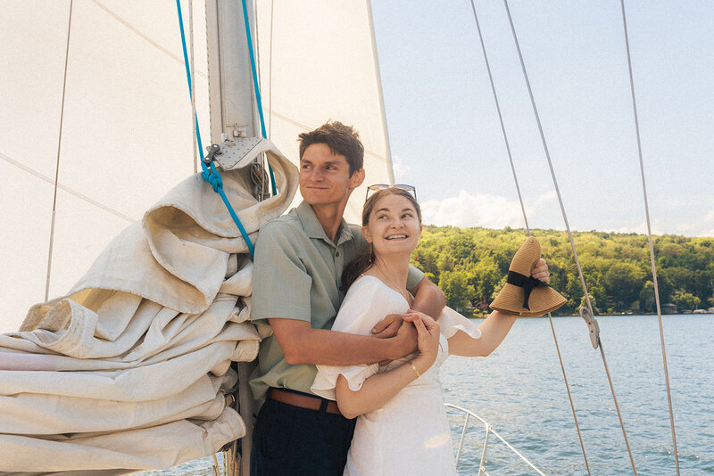 a couple that had just eloped lounging on a sailboat on Cayuga Lake new york during a sunny afternoon