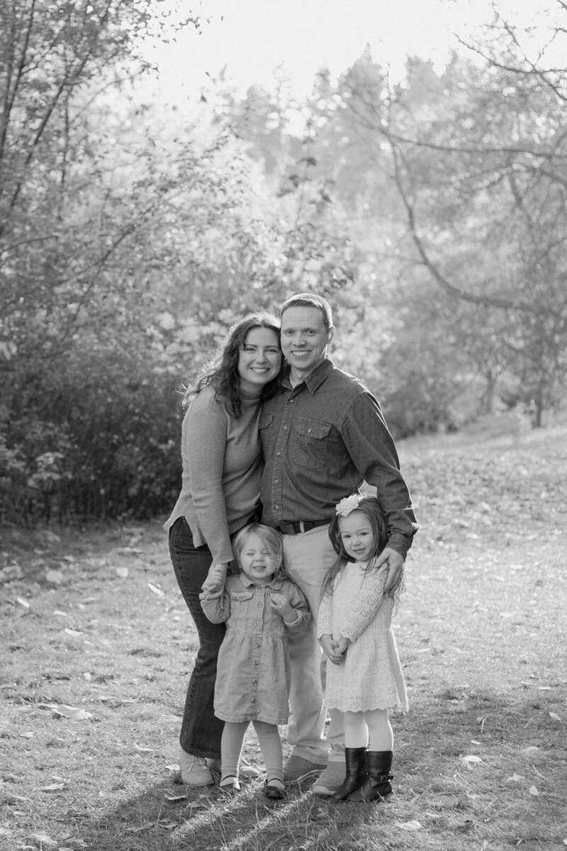 family standing and smiling together while getting their family pictures spokane wa