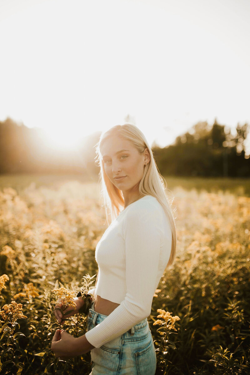 Minnesota senior photographed in a field at sunset