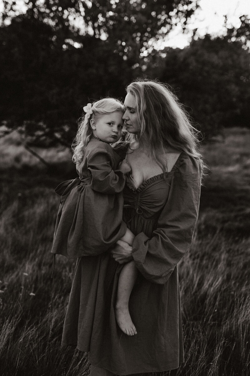 en mamma har sin dotter på höften