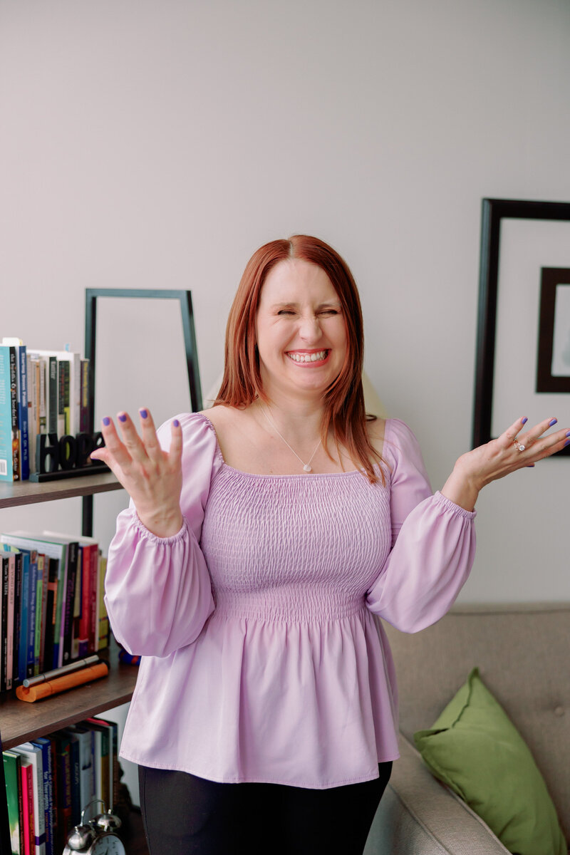 A person puts their hands out while smiling.