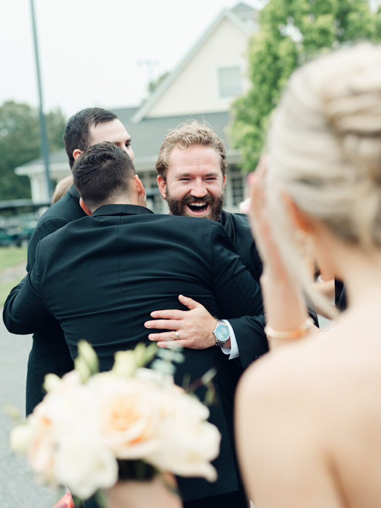 groom excited and hugging friend, taken by one of the top baltimore photographers
