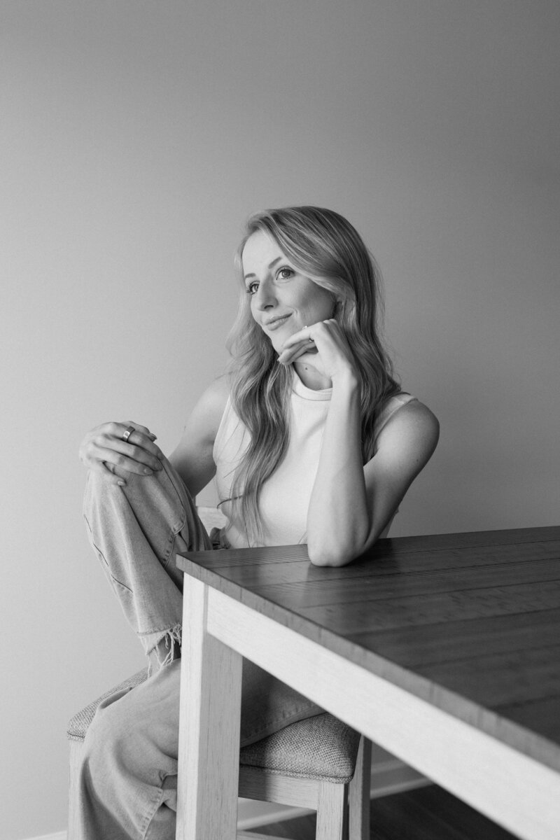 black and white photo of a girl sitting at a table