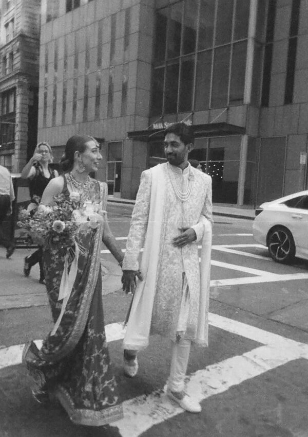 Snapshot from a Boston wedding film of the couple walking down a scenic road, hand in hand