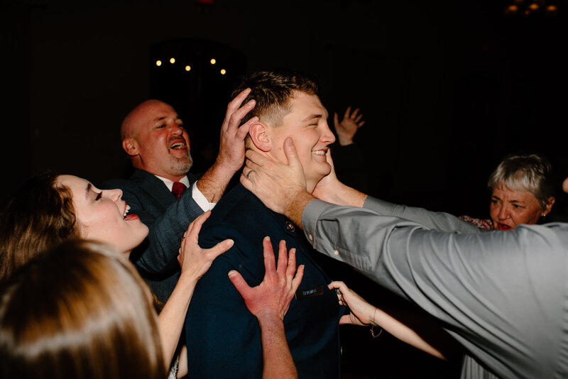 groom and his family dance with him at their reception