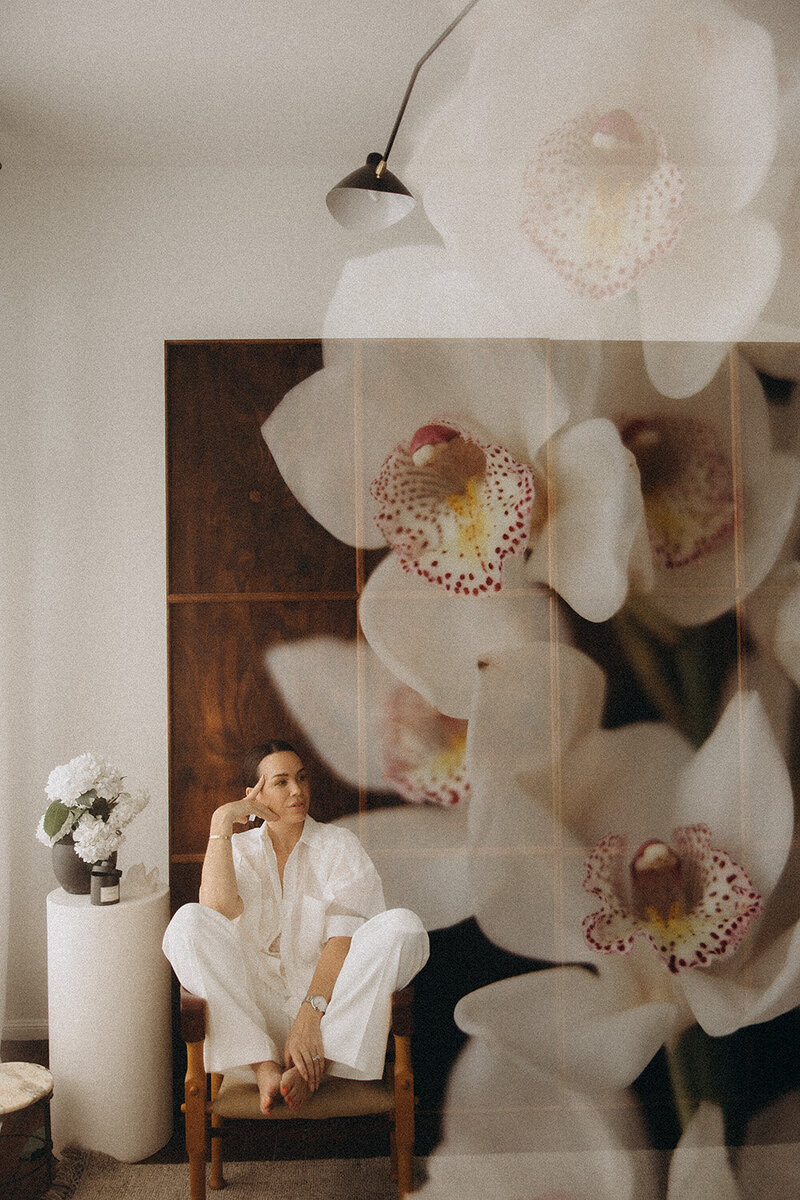 Sunshine Coast Brand photoshoot of a woman against a flower backdrop looking contemplative