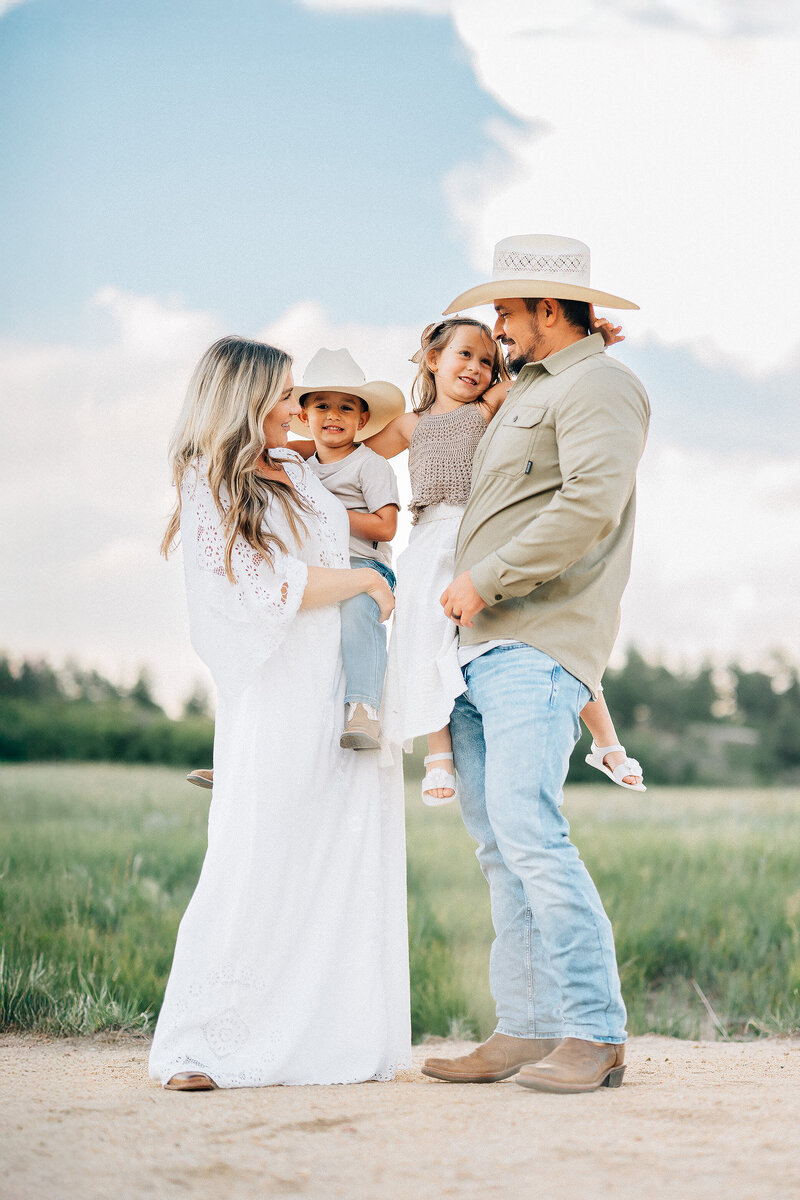 family of four view from below with mother holding son and dad holding daughter