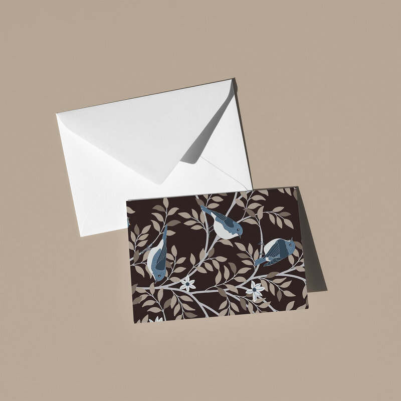 These A6 blank cards are perfect for sending a thoughtful note or simply keeping in your stationery drawer for special moments. Each card showcases a unique hand-drawn design - blue birds sitting on branches with white flowers on a deep burgundy brown background - by Green Acre Designs.