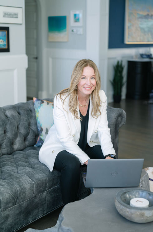 April Likins expert work life balance coach working on her laptop in her living room