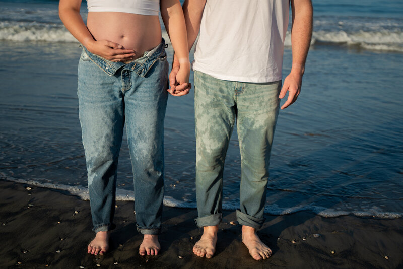 Couple holding hands and kissing  on the beach in San Diego, California