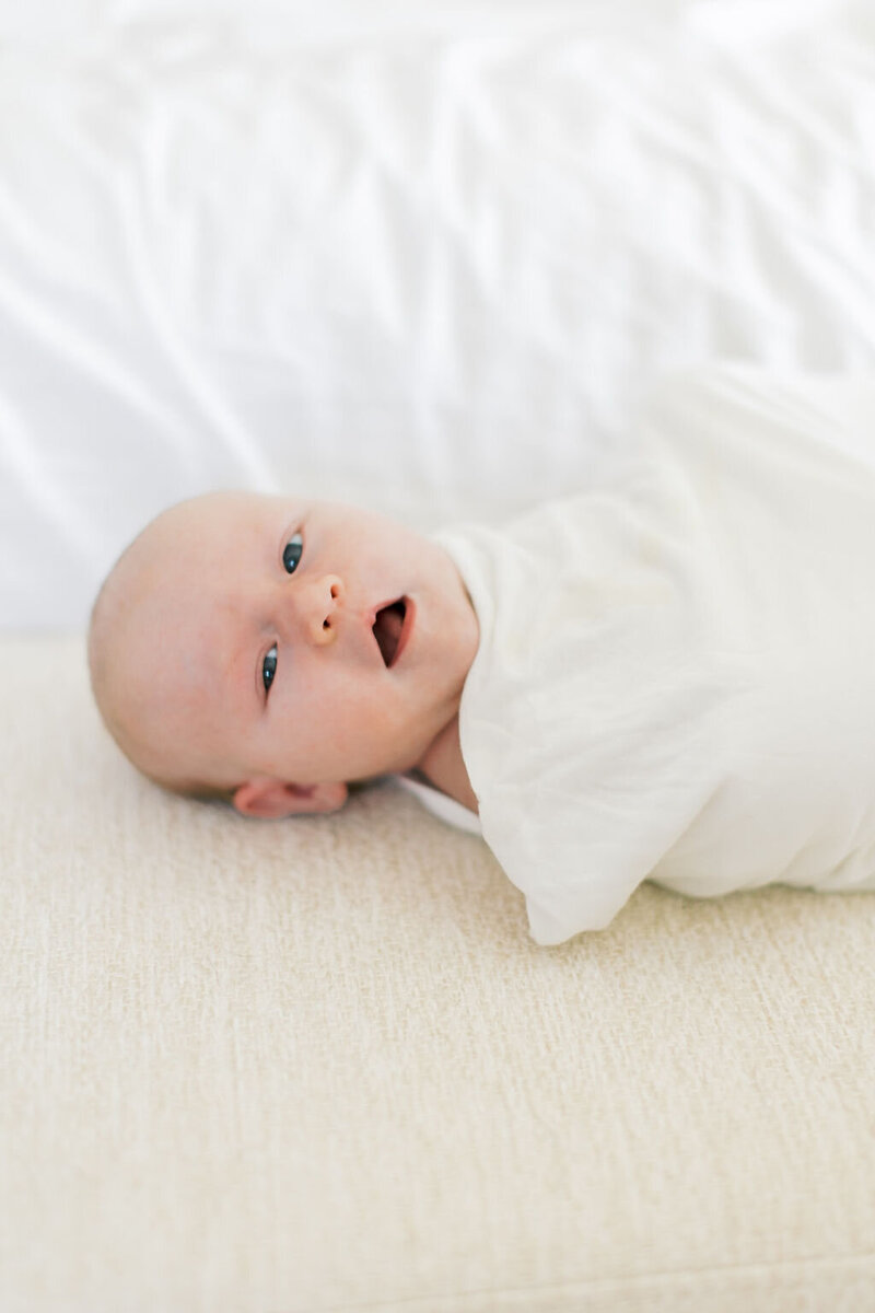 Outdoor senior portrait of a girl in a cream dress and cowboy boots walking along a wooden fence, captured by Raleigh Senior Photographer Lindsey Lambert Photography.