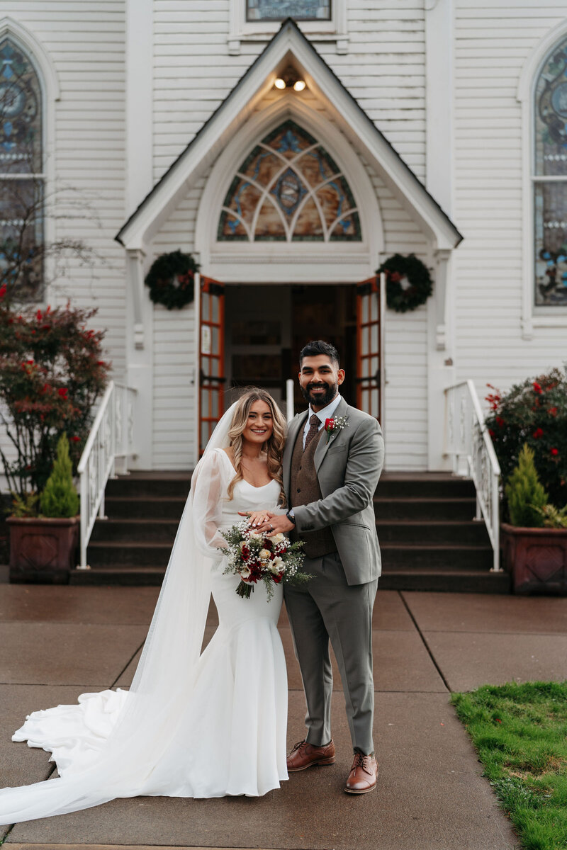 a couple standing outside a church on their wedding day