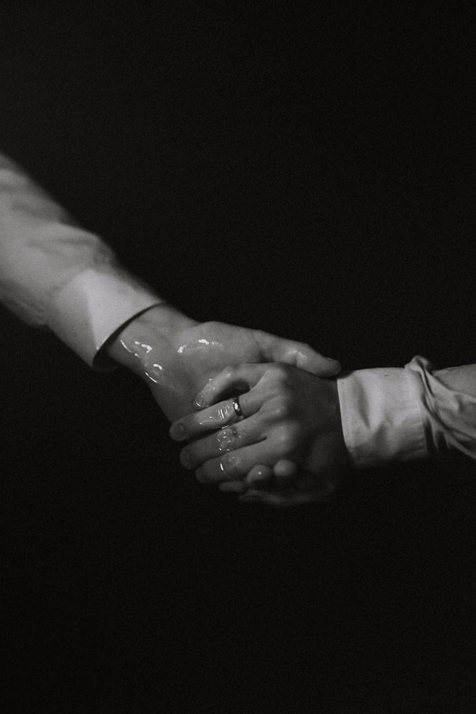 gay-elopement-couple-holding-hands-in-water-bw