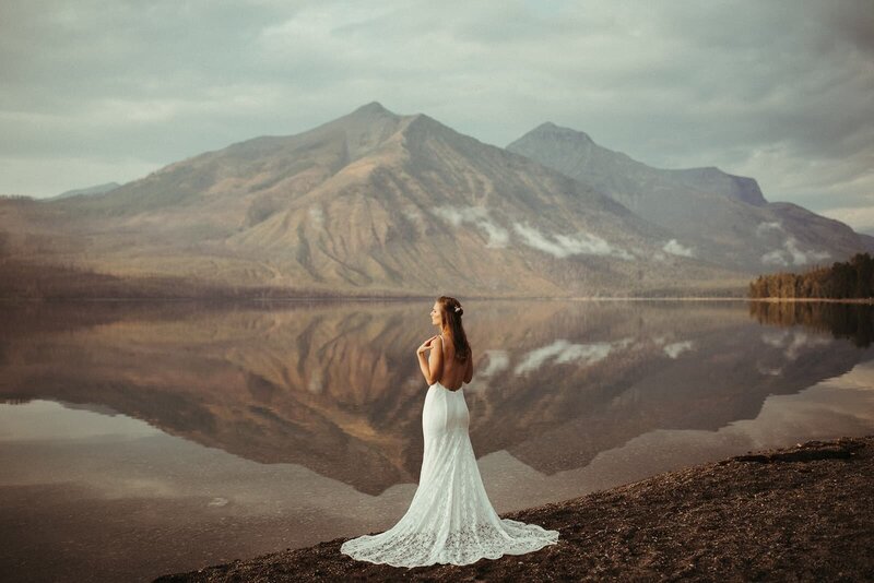 bride posing on beach in front of mountain