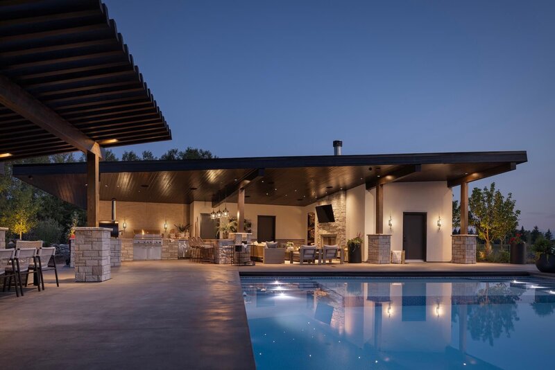 Outdoor backyard with pool house and outdoor kitchen for entertaining. 