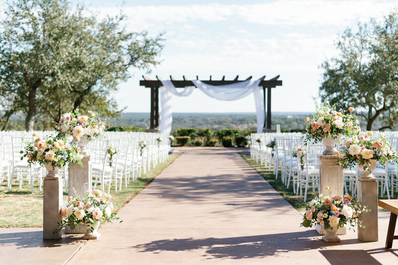 Bride and groom kissing while bridal party cheers around them