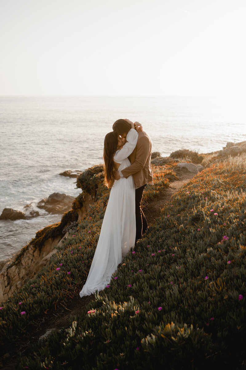 Couple hugging on cliff big sur bridal session