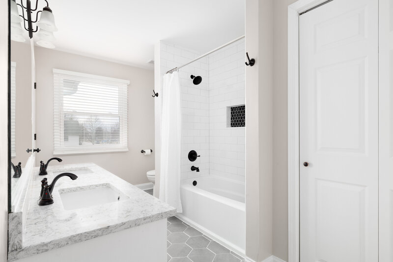 White walls and countertops for Simsbury bathroom remodel with gray floor tile.
