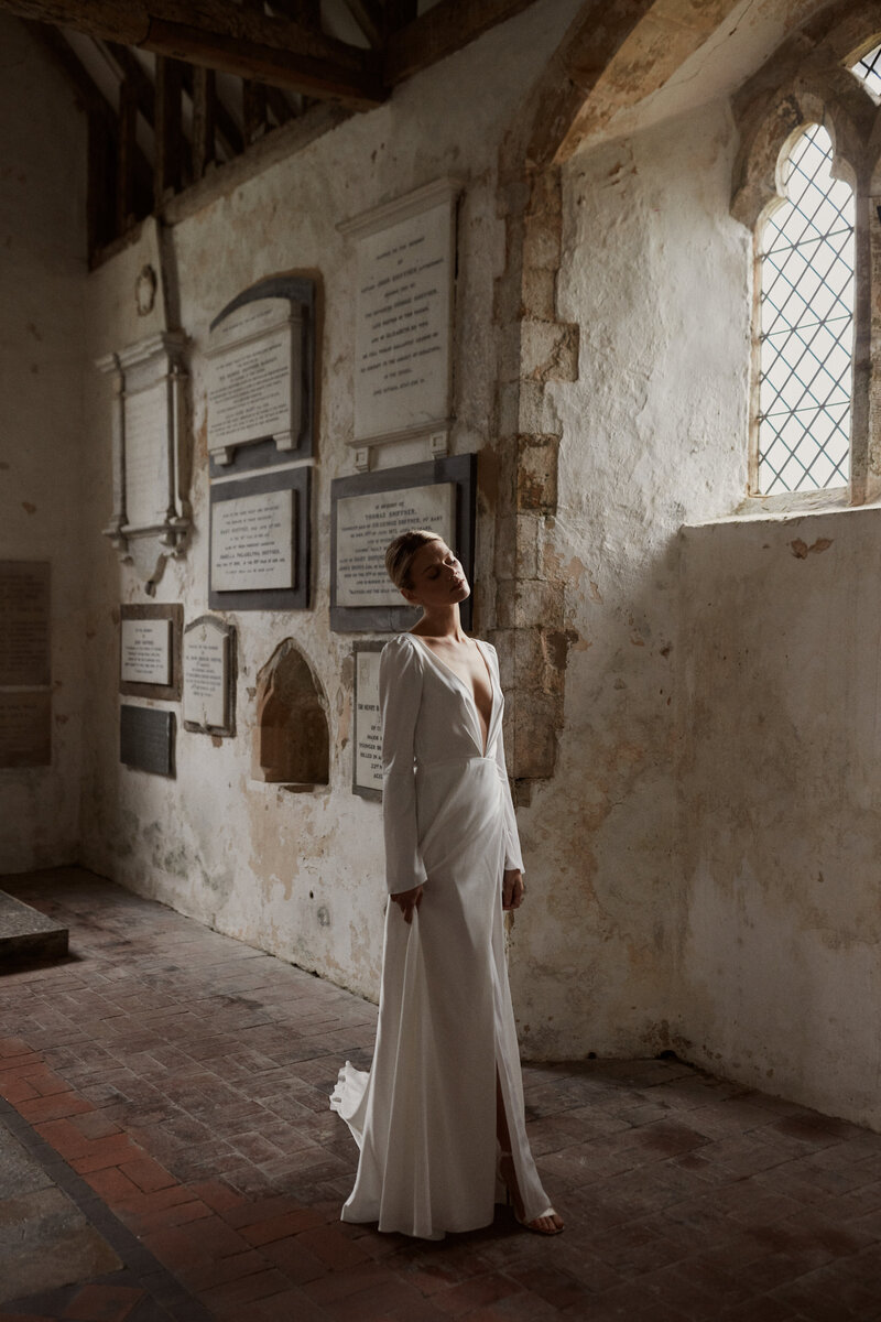 Long-sleeved wedding dress in silk worn by bride in chapel