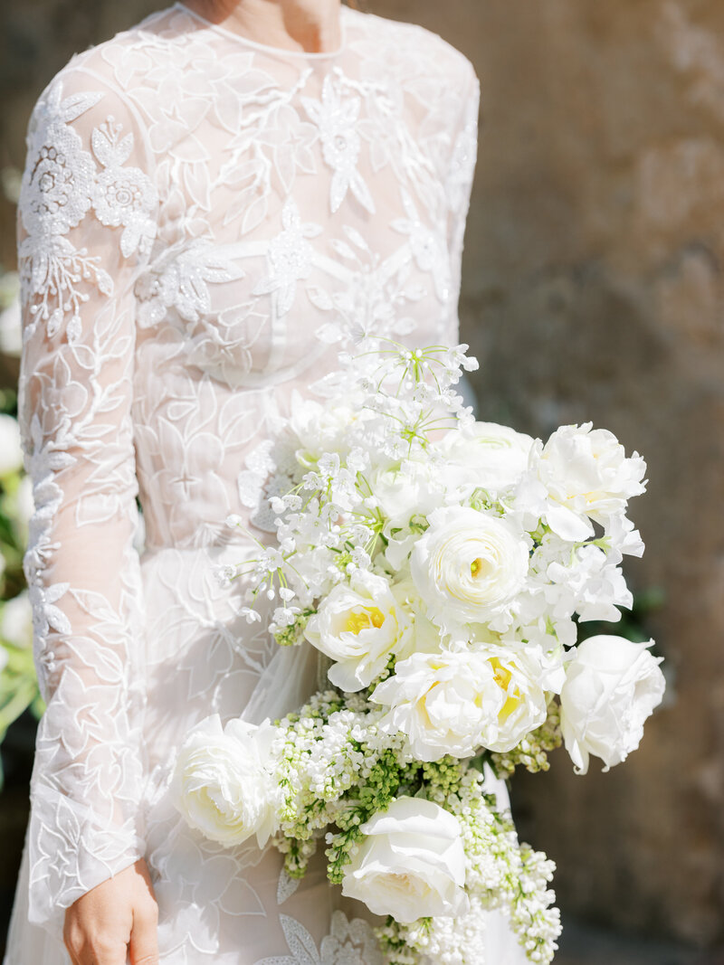 closeup of bride in designer gown holding an all-white floral bridal bouquet in Sintra, Portugal
