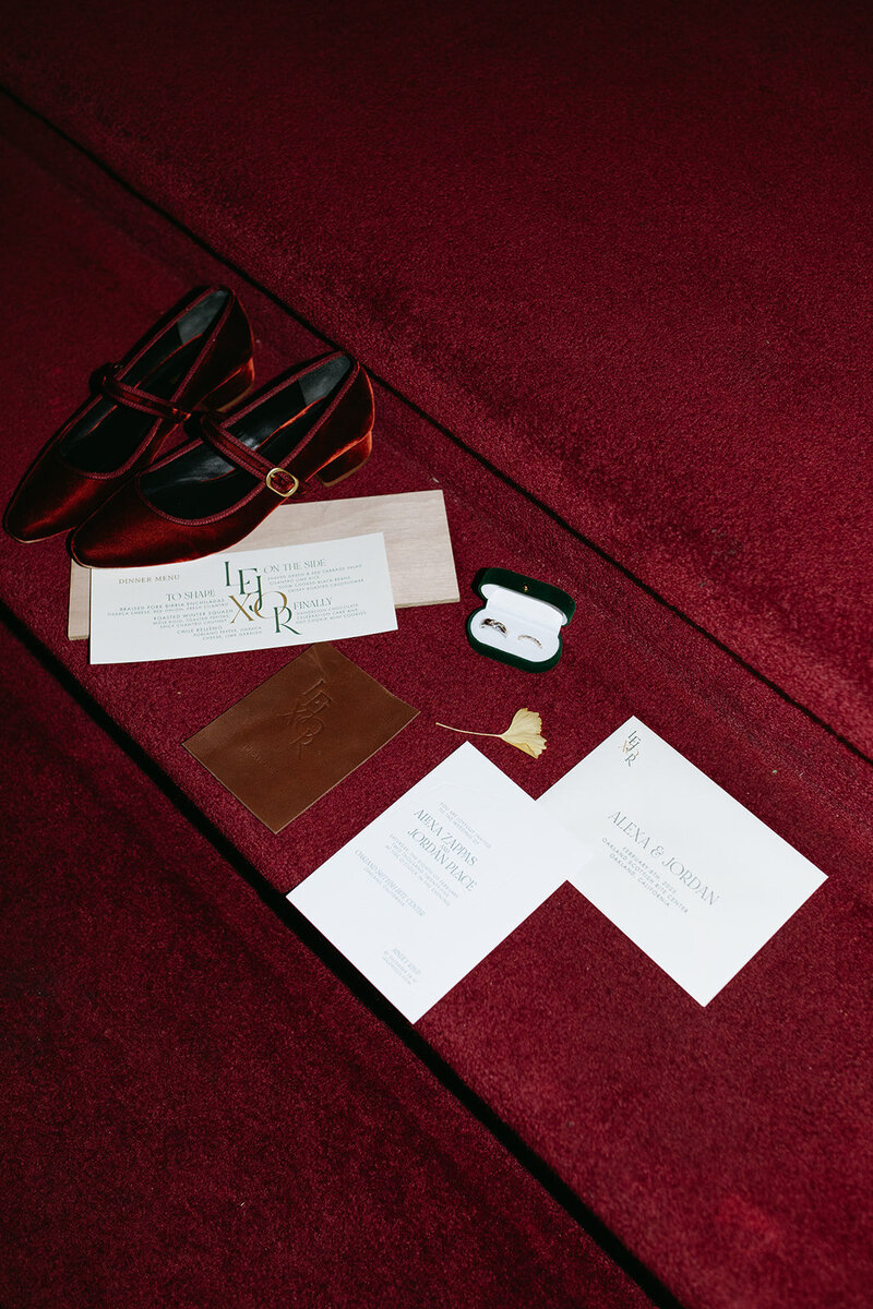 Wedding detail are laid out on red carpet in Oakland CA