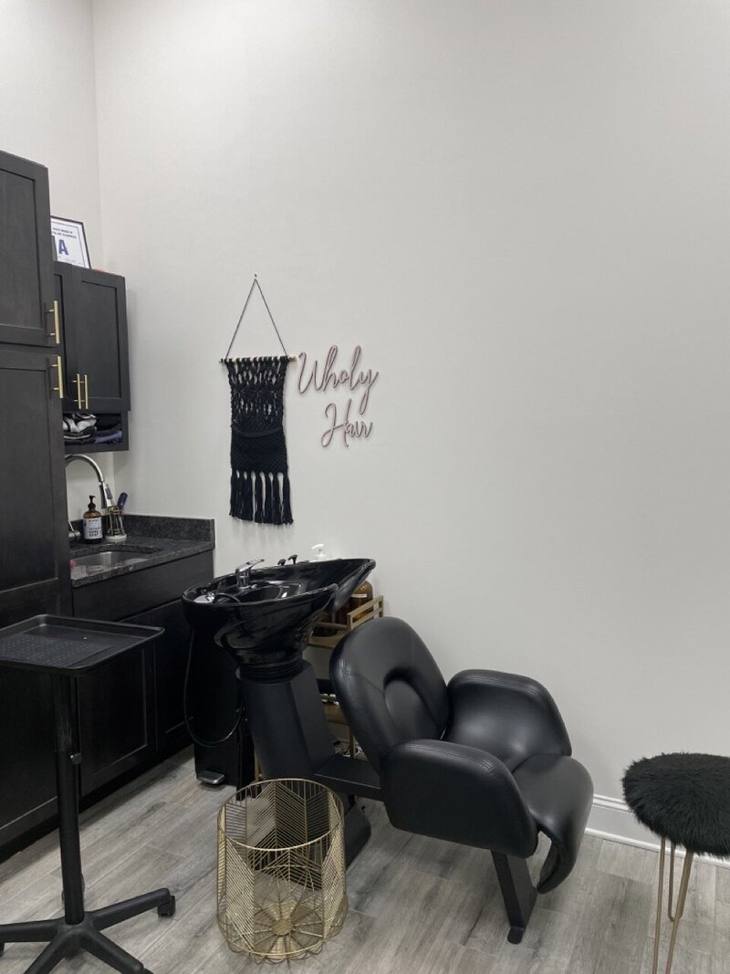 salon suite shampoo bowl with wholy hair sign on the wall