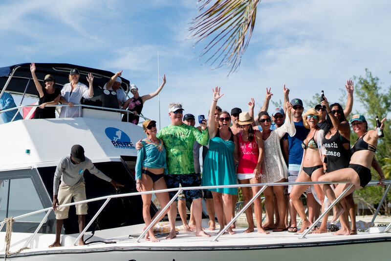Group of people on a boat waving at the camera in Belize