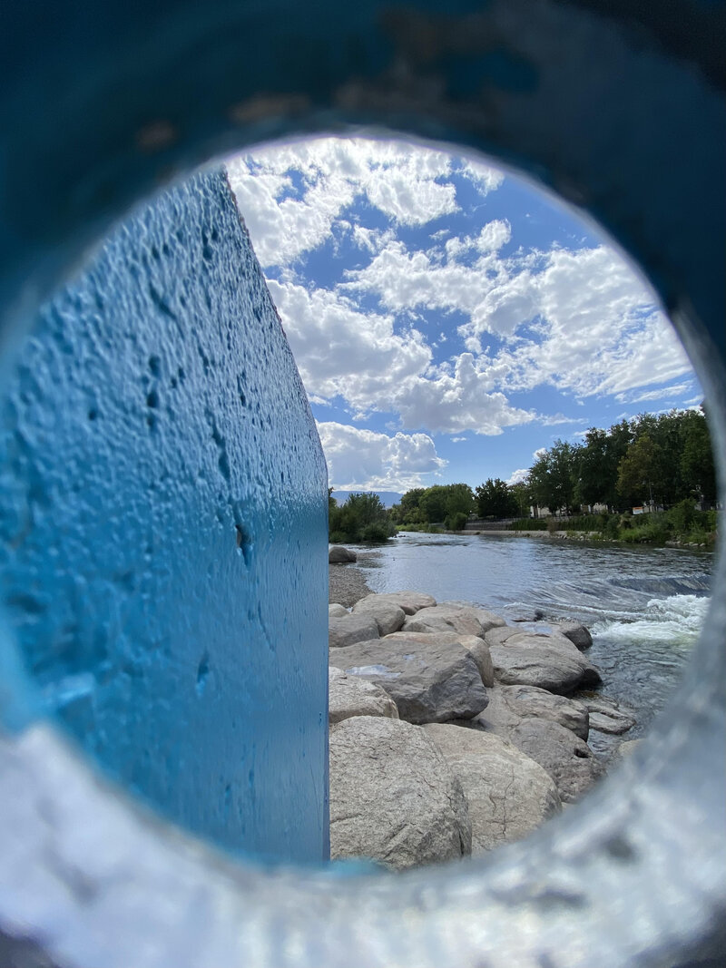 A scenic view of a river and sky framed by a blue structure, representing clarity, flow, and personal growth for seniors exploring psychedelic coaching in North Carolina.