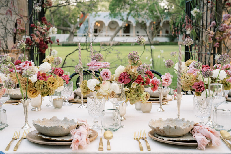 Stunning floral centerpiece and place settings at outdoor wedding reception