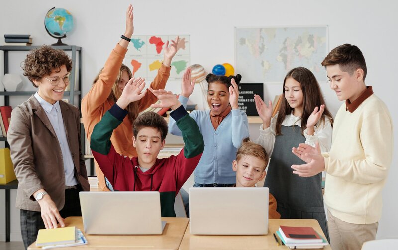teacher congratulting students for a job well done