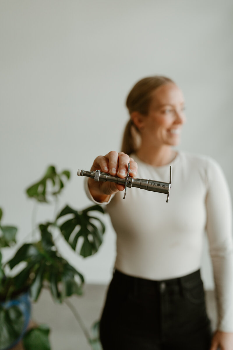 woman holding the integrator chiropractic tool