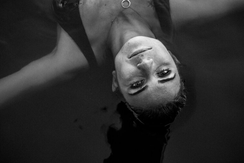 black and white photo of girl laying in water