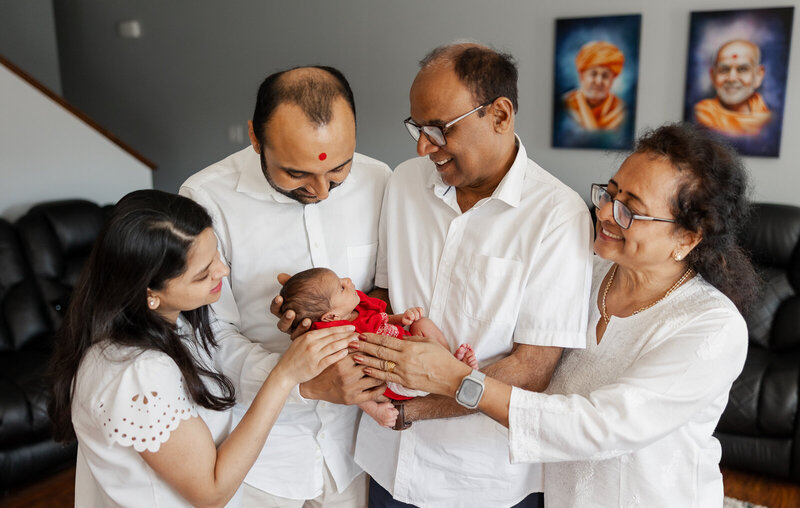 An in-home lifestyle newborn portrait of an extended family of grandparents, parents and infant son in their home in St. Louis, Missouri. 