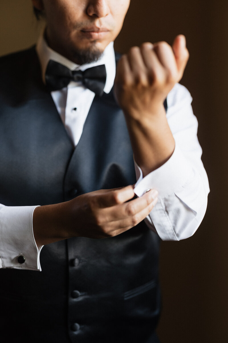 Groom fixing his cufflinks on his wedding day.
