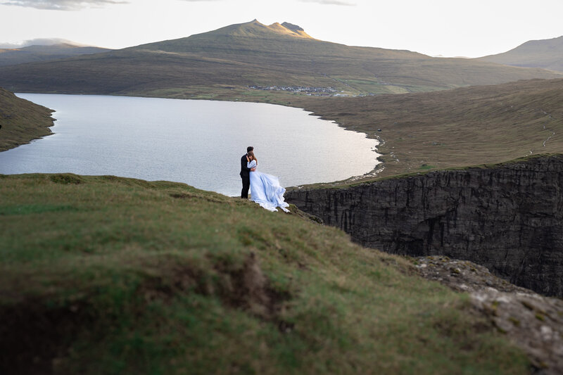 Faroe Islands elopement photography – adventurous couple on cliffs at Gásadalur waterfall.