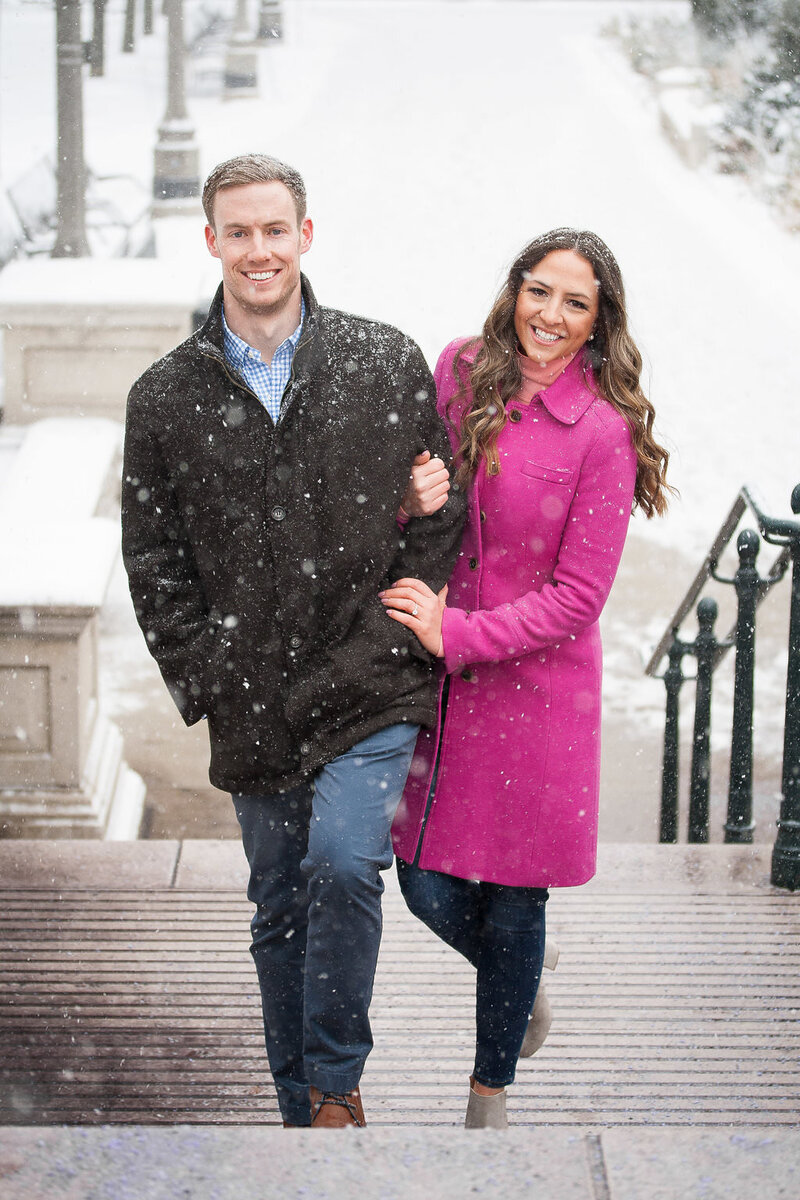 couple walk woodward during snowy winter detroit engagement session