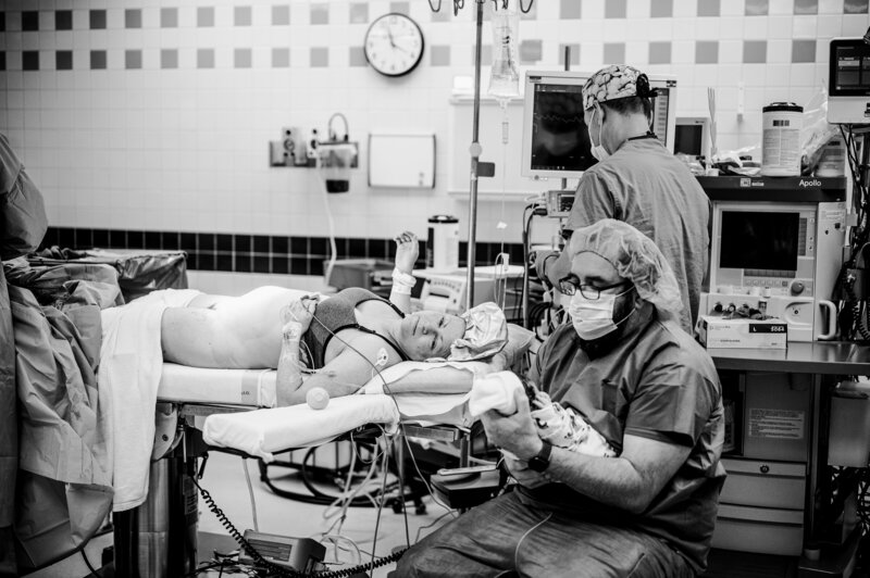 Black and white image of doctors assisting during cesarean birth — documentary-style Dallas–Fort Worth birth photography by Poppy + Blue Photography