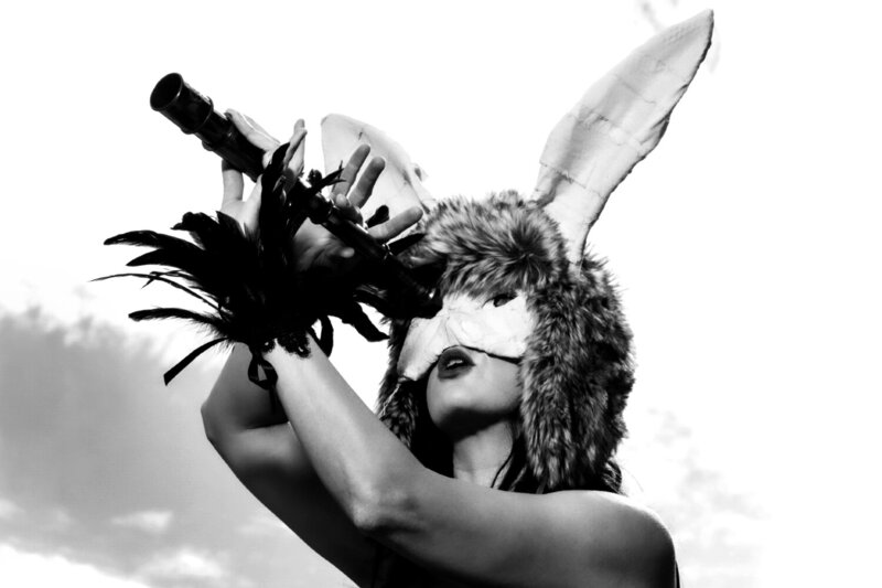 Musician portrait Los Angeles musician Vanderocker holding telescope while wearing furry hat mask and bunny ears black and white image