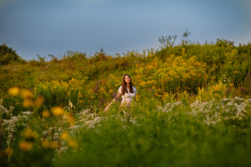 Girl standing in a field for her Boston Portrait Session.