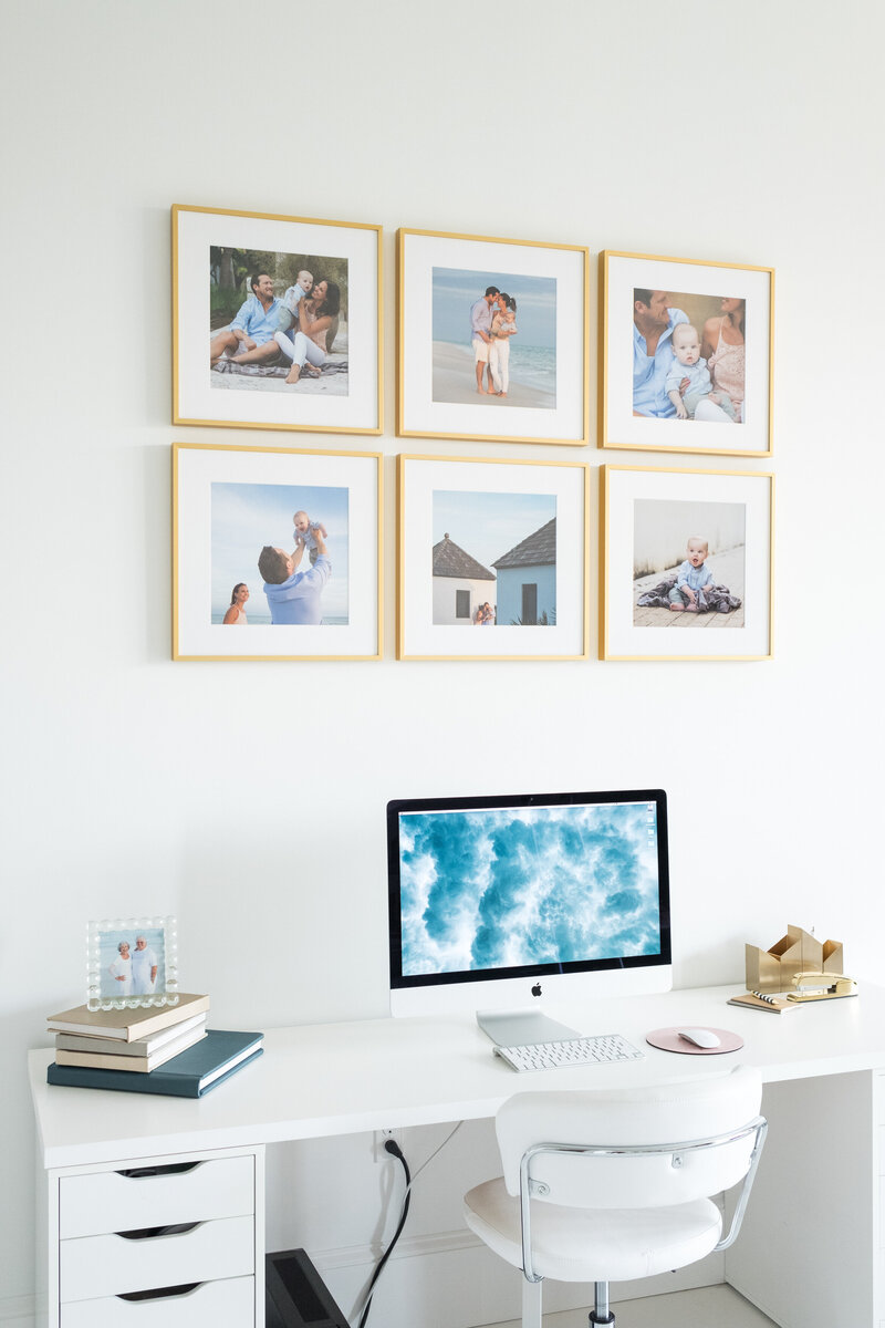Photos hung up on a wall above a desk