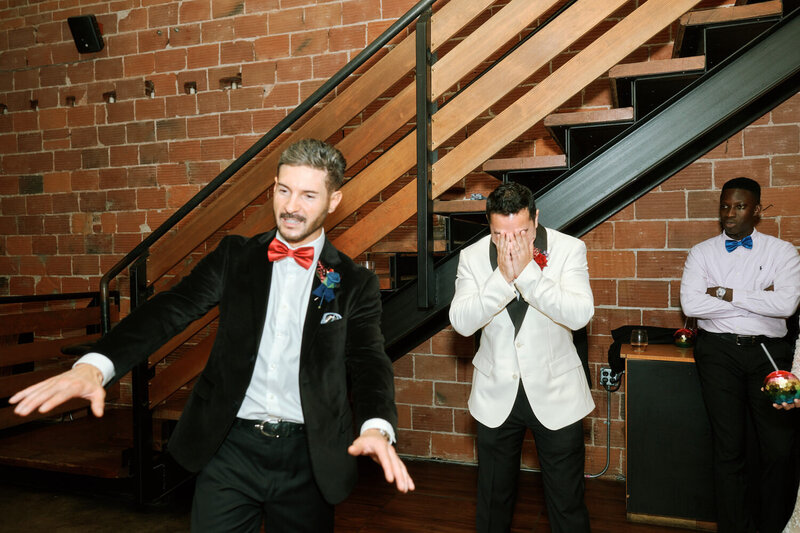 Groom hides his face as the best man gives a speech