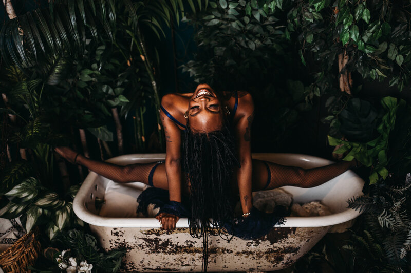 Flexible boudoir in a claw foot tub in an oasis doing a split