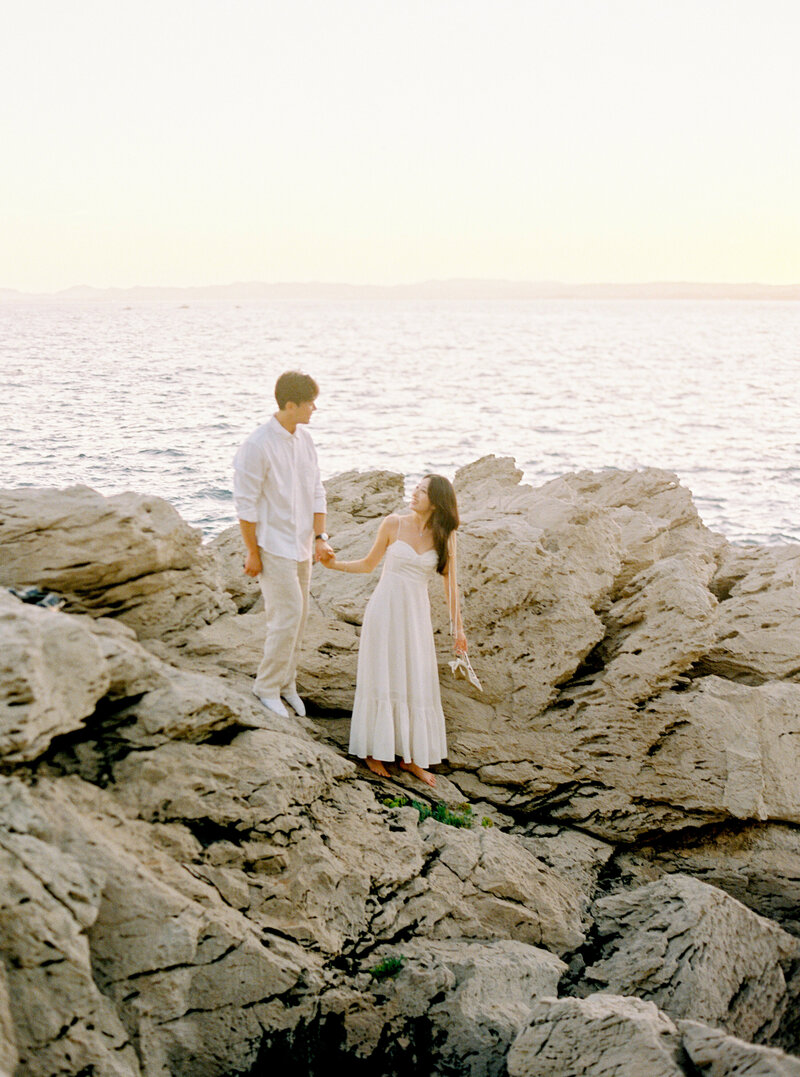 Amy and Tim hand to hand at the sunset, engagement romantic mood