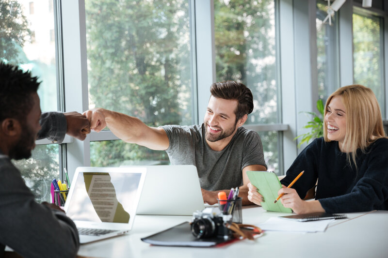 woman on notepad next to man  on laptop