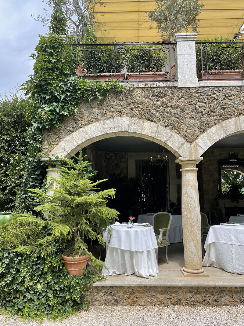 A refined and elegant writing desk at Borgo Santo Pietro with a large glass vase overflowing with white flowers and greenery