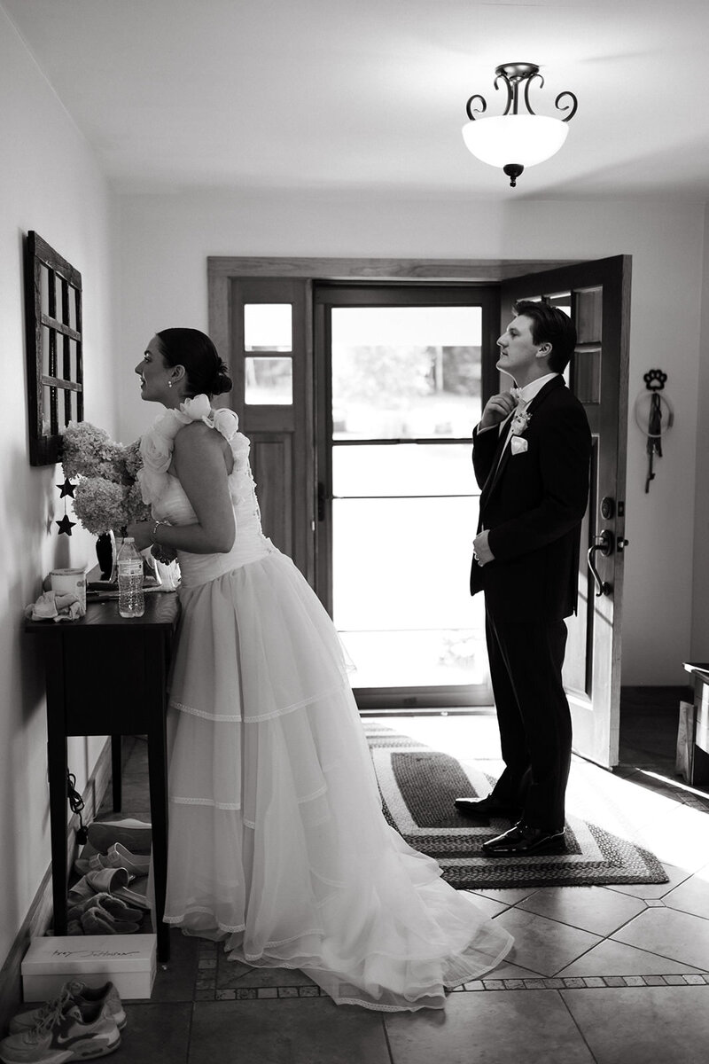 Bride and groom looking in the mirror before their wedding ceremony black and white photography