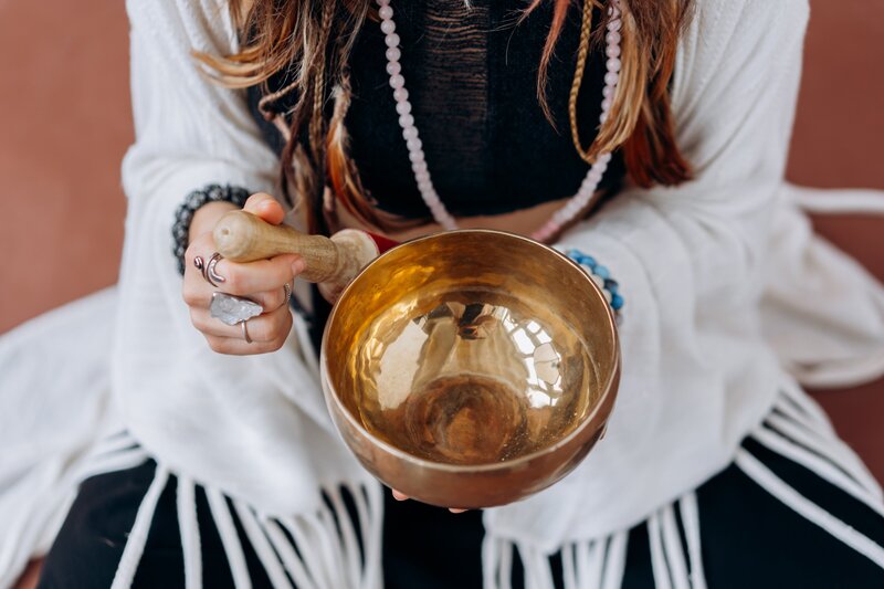 Healing woman playing a singing bowl. 